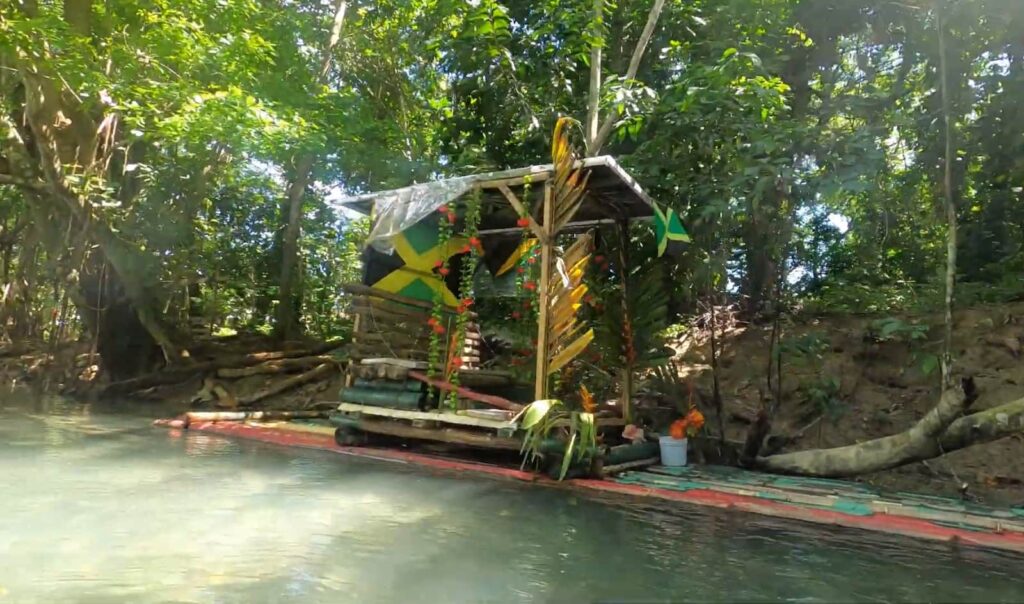 A colorful, makeshift raft docked along a verdant riverbank