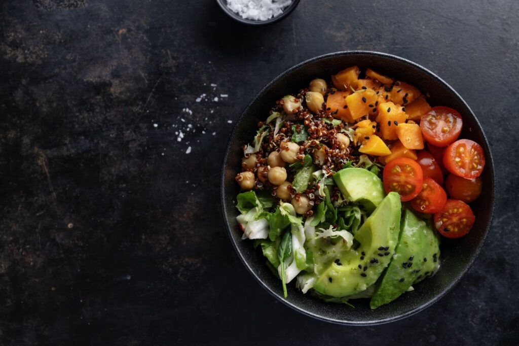 Top view of poke bowl with avocado quinoa and vegetables